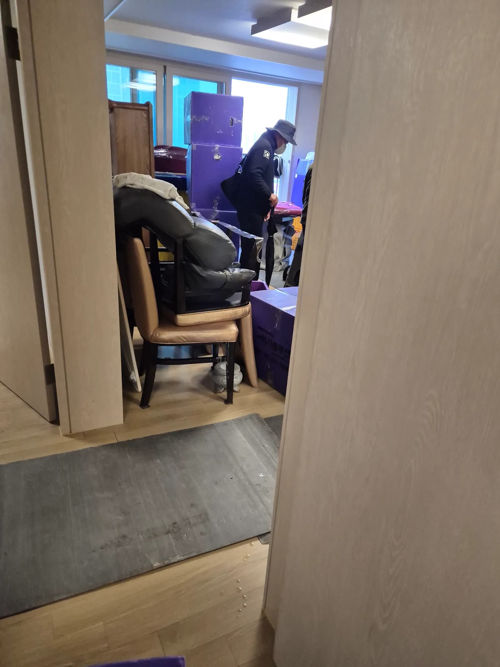 보라색 보호재로 가구 모서리를 감싸 운반하는 장면